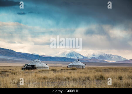 Due yurta in un paesaggio della Mongolia occidentale con montagne innevate a sfondi Foto Stock