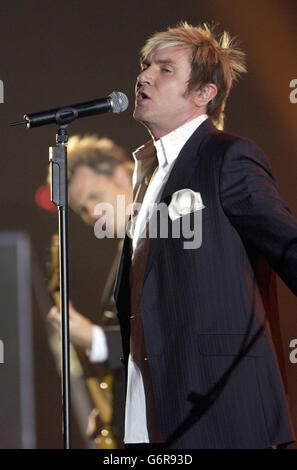 Simon le Bon della band pop degli anni ottanta Duran Duran ha suonato sul palco all'annuale Brit Awards 2004 presso Earls Court, nel sud-ovest di Londra. Foto Stock