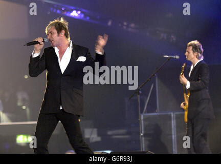 Simon le Bon (a sinistra) e John Taylor della band pop degli anni ottanta Duran Duran si esibiscono sul palco all'annuale Brit Awards 2004 presso Earls Court, nel sud-ovest di Londra. Foto Stock