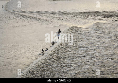 FOTO STANDALONE. Surfers, kyakers e wave-sciatori cavalcano la marea Severn Bore come passa Newnham, Gloucestershire. Foto Stock
