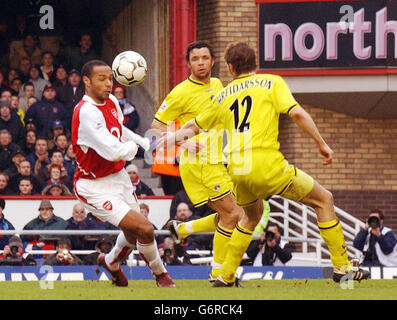 Thierry Henry dell'Arsenal (a sinistra) in azione contro Hermann Hreidarsson (a destra) di Charlton Athletic durante il Barclaycard Premiership Match a Highbury, a nord di Londra, sabato 28 febbraio 2004. Foto Stock