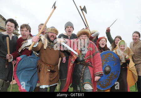 Il vero nome di Fjarn Sven David Marsey (al centro, a sinistra) e il vero nome di Njal Siggurdsson Neil Shepherd (al centro, a destra) con i loro compagni reenattori si preparano alla battaglia come parte del 30° Jorvik Viking Festival di York. Foto Stock