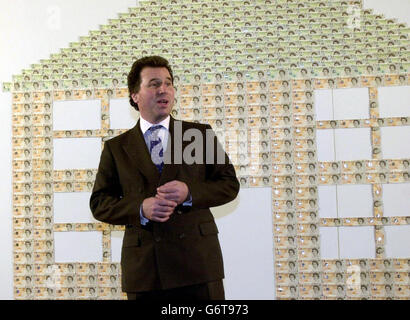 Il cancelliere ombra Oliver Letwin, in piedi contro un muro di banconote, svela una campagna pre-budget che sottolinea ciò che egli sostiene è la tassa extra del lavoro 5,000 all'anno per famiglia, presso la sede centrale del Tory Party a Londra. Il cancelliere ombra Oliver Letwin oggi ha sfidato Tony Blair e Gordon Brown a 'venire a posto' sugli aumenti fiscali che egli ha previsto seguiranno una terza vittoria delle elezioni generali del New Labour. Foto Stock