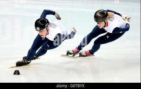 Charlotte Gilmartin (a sinistra) e Elise Christie (a destra) durante la pratica di skatering di velocità nel Palazzo di pattinaggio di Iceberg, durante i Giochi Olimpici di Sochi del 2014 a Krasnaya Polyana, Russia. Foto Stock