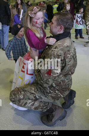 Il tenente di volo Andy Power con suo figlio Harry (a sinistra), di tre anni, e la figlia Jessica Power, di sette anni, come membri di 617 Squadron, i Dambuster, ritornano a RAF Lossiemouth, a Moray, dall'Afghanistan, prima di sciogliersi fino al 2016. Foto Stock