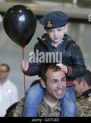 Il tenente di volo Mo Abdallah e suo figlio Adam, di quattro anni, come membri di 617 Squadron, i Dambusters, ritornano a RAF Lossiemouth, a Moray, dall'Afghanistan, prima di sciogliersi fino al 2016. Foto Stock