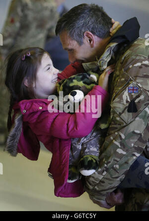 Il sergente Richard Hawley e sua figlia Aoife, di sei anni, come membri di 617 Squadron, i Dambusters, ritornano a RAF Lossiemouth, a Moray, dall'Afghanistan, prima di sciogliersi fino al 2016. PREMERE ASSOCIAZIONE foto. Data immagine: Martedì 4 febbraio 2014. L'unità verrà sciolta il 1° aprile come parte del progetto di tiraggio della forza di Tornado GR4, ma si riformerà nel 2016, prendendo la consegna del ''altamente avanzato'' Lightning II fighter. Lo squadrone partì per l'Afghanistan in ottobre, il suo schieramento finale per fornire ricognizione aerea alle forze di terra a guida afghana. Probabilmente è il più Foto Stock