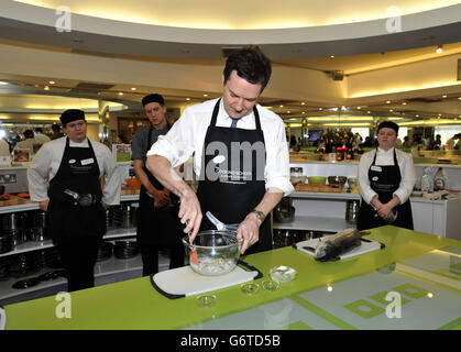 Il Cancelliere dello scacchiere George Osborne si unisce a chef apprendisti in una scuola di cucina durante una visita al Dean Clough Mills di Halifax, dove ha visitato piccole imprese durante il suo viaggio nello Yorkshire occidentale, per promuovere l'introduzione della concessione di occupazione in aprile. Foto Stock