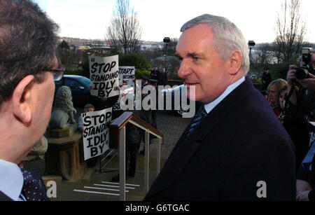 John Hume (L), ex leader e premio Nobel della SDLP, saluta il primo ministro irlandese Bertie Ahern all'Università di Ulster, Derry, Irlanda del Nord, dove Ahern ha parlato con un'udienza selezionata sul ruolo dell'UE nella pace mondiale. Sullo sfondo si possono vedere i manifestanti che hanno richiesto più azioni da parte di Ahern nel processo di pace in Irlanda del Nord. Foto Stock