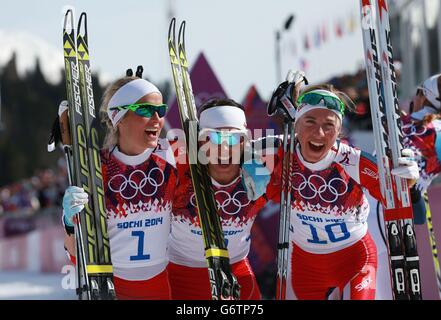 Marit Bjoergen (centro) in Norvegia celebra la vittoria della contea di Cross Ladies a 30 km con Therese Johaug (a sinistra) e Kristin Stoermer Steira durante i Giochi Olimpici Sochi del 2014 a Sochi, Russia. Foto Stock
