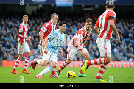 Samir Nasri di Manchester City affronta la palla con Marko Arnautovic di Stoke City (a destra) e Charlie Adam di Stoke City (a sinistra) durante la partita della Barclays Premier League all'Etihad Stadium di Manchester. Foto Stock