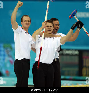 David Murdoch (a destra), Michael Goodfellow (a sinistra) e Scott Andrews festeggiano alla fine della Semifinale maschile contro la Svezia al Ice Cube Curling Centre durante i Giochi Olimpici Sochi del 2014 a Sochi, Russia. Foto Stock