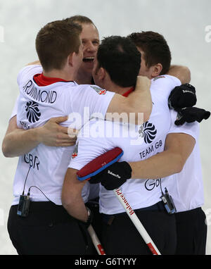 Il salto della Gran Bretagna David Murdoch (centro a destra) festeggia con Greg Drummond (a sinistra), Michael Goodfellow e Scott Andrews (a destra) dopo aver vinto la semifinale maschile contro la Svezia al Ice Cube Curling Center durante i Giochi Olimpici Sochi del 2014 a Sochi, Russia. Foto Stock