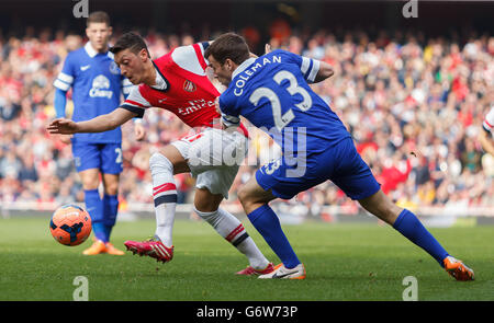 Mesut Ozil di Arsenal, (a sinistra) battaglie per il possesso della palla con il Coleman Seamus di Everton, (a destra) Foto Stock