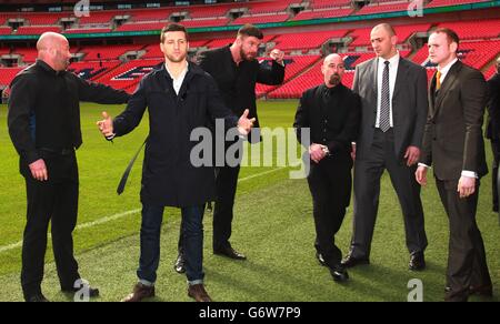 Carl Froch (seconda a sinistra) reagisce dopo aver spinto George Groves (a destra) sul campo di Wembley a seguito di una conferenza stampa al Wembley Stadium, Londra. Foto Stock