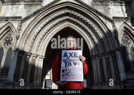 Un protestante contro la "tassa sulle camere da letto" del governo dimostra al di fuori della High Court di Londra. Foto Stock