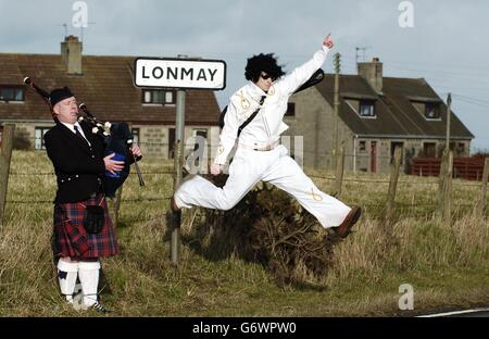 Piper Duncan Edwards con il sosia di Elvis Ian Hainey, nel villaggio di Lonmay nell'Aberdeenshire, dove lo scrittore Allan Morrison sostiene di aver rintracciato le radici di Elvis Presley indietro di 250 anni, fino al piccolo insediamento nel nord-est della Scozia. Nonostante questa sia una delle numerose affermazioni sulle origini di Presley, l'autore, con sede a Greenock, vicino a Glasgow, insisteva sul suo libro non ancora pubblicato - la Pressecia di Presley - si sarebbe levato in piedi fino a scrutare. Foto Stock