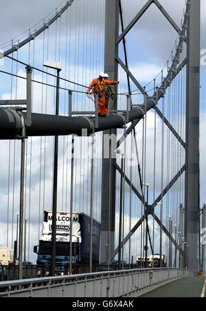 Gli ingegneri camminano lungo uno dei due cavi di diametro di 2 piedi che attraversano la campata centrale di 3,300 piedi tra le due torri principali del Forth Road Bridge. Il Forth Road Bridge festeggerà il suo 40° anniversario alla fine di quest'anno, anche se un progetto di ristrutturazione di 3.5 milioni sul ponte si sta rivelando un'occasione meno che felice per i pendolari del fine settimana bloccati in lunghe code. I lavori iniziati sul progetto il 16 aprile vedranno la carreggiata sud chiusa ogni fine settimana fino a giugno con la Forth Estuary Transport Authority che dona 10,000 alle comunità locali per dare un'idea Foto Stock