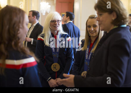 Il Segretario di Stato per la cultura, i media e lo sport Maria Miller (destra), saluta i membri del Winter Paralymic Team GB, tra cui gli sciatori vincitori della medaglia d'oro Kelly Gallagher (centro) e Charlotte Evans (seconda destra), durante un ricevimento tenuto a Downing Street, nel centro di Londra, A seguire le squadre tornano dai Giochi Paralimpici invernali Sochi. Foto Stock