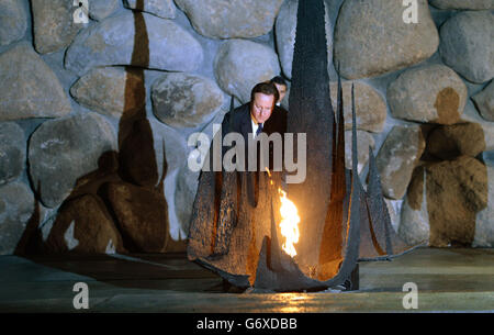 Il primo ministro David Cameron riaccende la fiamma eterna per i ricordi delle vittime dell'olocausto al museo dell'olocausto, Yad Vashem a Gerusalemme, Israele. Foto Stock