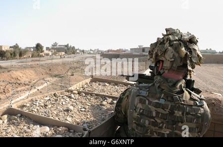 Il soldato si affaccia sulla recinzione perimetrale della base operativa principale Lashkar Gah nella provincia di Helmand mentre le truppe britanniche si preparano a ritirarsi e consegnare alle forze di sicurezza afghane. 24/02/2014. Foto Stock