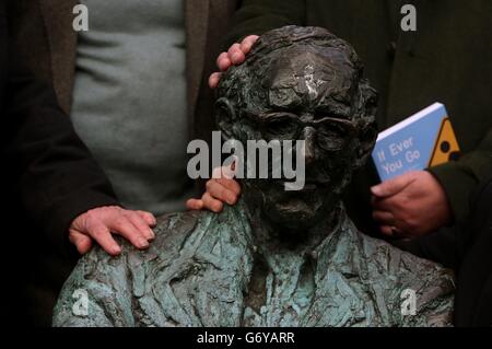 Il poeta e i collaboratori di "If You Ever Go: A map of Dublin in Poetry and Song" riposano le mani sulla statua di Patrick Kavanagh sul Canal Grande di Dublino, al lancio del festival Dublino: One City One Book di quest'anno. Foto Stock