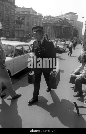 Un poliziotto lascia la Banca d'Inghilterra nella città di Londra con materiale raccolto sulla scena dell'esplosione della bomba postale che ha ferito tre uomini nella stanza della banca. Foto Stock