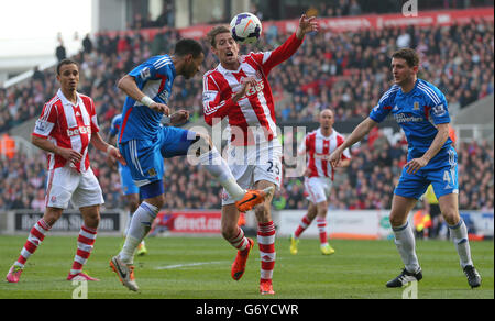 Peter Crouch (centro) di Stoke City è tenuto fuori da Liam Rosier di Hull City (a sinistra) e Alex Bruce di Hull City durante la partita della Barclays Premier League al Britannia Stadium, Stoke on Trent. Foto Stock