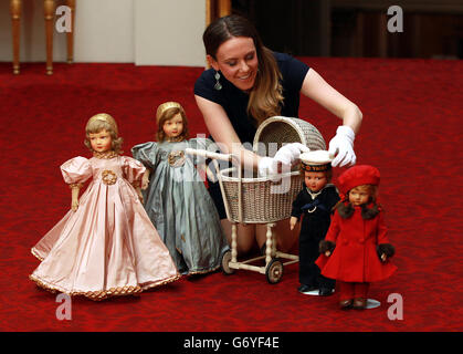 La curatrice Anna Reynolds detiene bambole parigine appartenenti alla regina Elisabetta II e alla principessa Margaret al lancio della mostra estiva Royal Childhood a Buckingham Palace, Londra, che celebra l'infanzia reale con giocattoli e regali di famiglia appartenenti ai bambini reali quando stavano crescendo. Foto Stock