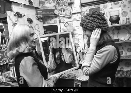 Margo MacDonald (l), parlamentare nazionale scozzese per Govan, aiuta Jan Porter a scegliere un cappello presso il negozio Oxfam di Parliament Street, Westminster, dove oggi la signora MacDonald era un assistente di vendita volontario. Foto Stock