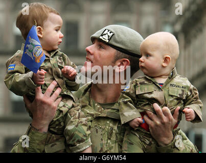 Trooper Colin qua del Royal Scots Dragoon Guards con il suo figlio di un anno Harly qua (a sinistra) e il nipote di sei mesi Colden McFarlane, dopo una parata di ritorno per le strade di Glasgow. La parata segna il ritorno del reggimento da un dispiegamento di sei mesi a Kabul, Afghanistan. Foto Stock