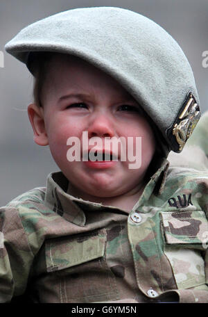Trooper Colin qua dal figlio di un anno della Royal Scots Dragoon Guards Harly qua nelle braccia di suo padre dopo una parata di ritorno per le strade di Glasgow, la parata segna il ritorno del reggimento da uno schieramento di sei mesi a Kabul, Afghanistan. Foto Stock