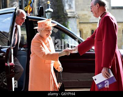 La regina Elisabetta II e il duca di Edimburgo (a sinistra) sono accolti dal decano di Windsor David Conner (a destra) che arriva per una visita per commemorare il 150° anniversario dell'RCO alla Cappella di San Giorgio al Castello di Windsor. Foto Stock