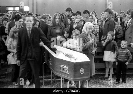 I lutto hanno passato la bara di Padre Hugh Mullan, alla Chiesa Cattolica Romana di Corpus Christi nella tenuta di Ballymurphy dopo la Messa di Requiem. Padre Hugh, 37 anni, è stato ucciso durante il bagno di sangue di lunedì sera a Belfast, che si è verificato dopo l'annuncio di internamento di terroristi, dopo aver tentato di dare ultimi riti ad un parishioner ferito. Fu curato di San Giovanni in Falls Road e sarà sepolto nella sua città natale di Portaferry nella contea di Down, Irlanda del Nord. Foto Stock