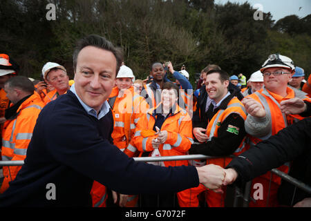 Il primo ministro David Cameron guarda intorno mentre incontra i lavoratori ferroviari durante una visita alla stazione ferroviaria di Dawlish a Dawlish, Devon, dopo la riapertura della linea ferroviaria distrutta dalla tempesta. Foto Stock