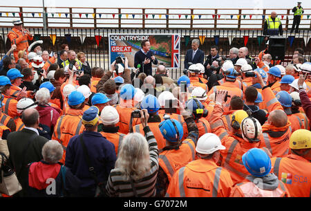 Il primo ministro David Cameron si rivolge ai lavoratori ferroviari durante una visita alla stazione ferroviaria di Dawlish a Dawlish, Devon, dopo la riapertura della linea ferroviaria distrutta dalla tempesta. Foto Stock