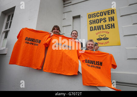 La gente del posto reggono su t-shirt dicendo 'lavoro fatto grazie all'esercito arancione' e 'Dawlish febbraio-aprile 2014' alla stazione ferroviaria di Dawlish, Devon, durante una visita del primo ministro David Cameron, dopo la riapertura della linea ferroviaria distrutta dalla tempesta. Foto Stock