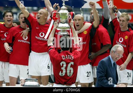 I giocatori del Manchester United, guidato da Roy Keane (al centro), festeggiano la vittoria di Millwall 3-0 nella finale della fa Cup al Millennium Stadium di Cardiff. Per la presentazione della Coppa i giocatori Uniti hanno donato delle camicie recanti 'davis 36' in memoria di Jimmy Davis il loro compagno di squadra che è morto in un incidente stradale lo scorso agosto. Foto Stock