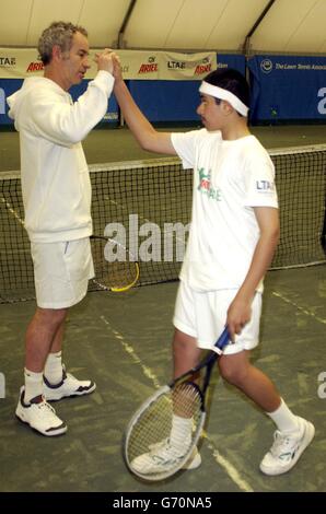 La leggenda del tennis John McEnroe serve un campione e aiuta Ariel Tennis Ace Shaakir Salam, da Tyne-in-wear, a preparare le grandi finali della celebrità Wimbledon il 14 giugno, alla Lawn Tennis Association Academy. Foto Stock