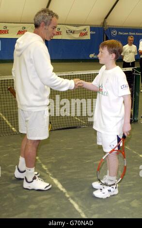 La leggenda del tennis John McEnroe serve un campione e aiuta Ariel Tennis Ace Garry Smith, da Glasgow, a preparare la grande celebrità Wimbledon finale il 14 giugno, alla Lawn Tennis Association Academy. Foto Stock