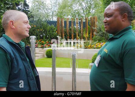 Mike Waring (a sinistra) da Leeds, West Yorkshire, e Abel Lephalala, da Durban, Sudafrica, Guardate il giardino che hanno contribuito a costruire intitolato "dalla libertà al futuro" in mostra al Chelsea Flower Show di quest'anno. Il giardino, una celebrazione dei collegamenti tra Leeds e Durban, è stato ispirato dal viaggio di vita di Nelson Mandela. La scultura in acqua, composta da quattro barre metalliche, ricorda le barre cellulari di Mandela durante la sua incarcerazione sull'isola di Robben. Lo spettacolo dei fiori si apre al pubblico martedì 25 maggio e si svolge fino al 28 maggio. Foto Stock