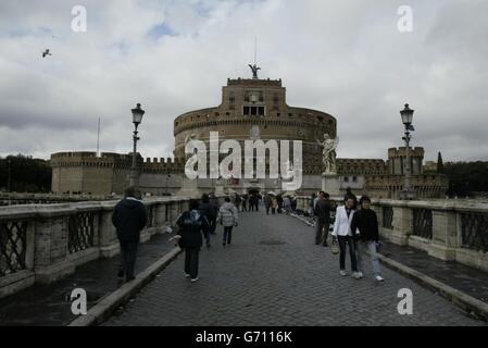 Il Castello dell'Angelo Santo, come si chiama Castel Sant'angelo, assomiglia alla base rotta di un calice gigante. La sua immensa massa rotonda di pietra domina l'ansa centrale del fiume Tevere. Questa fortezza proibente era una volta un mausoleo marmoreo, molto più grande dell'attuale struttura, che l'imperatore Adriano aveva costruito per sé e per i Cesari successivi. Ci sono stati ranghi di statue colossali un boschetto sospeso di alberi di emlock, una sottile torre centrale, e così via - ornamenti molto tempo fa distrutto. Un passaggio sopraelevato si snoda dal castello attraverso il Borgo fino al Vaticano Foto Stock