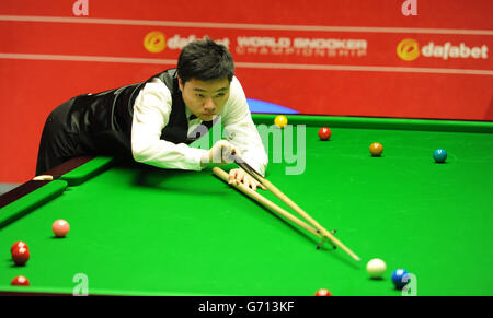 Ding Junhui al tavolo nella sua prima partita contro Michael Wasley durante il Dafabet World Snooker Championships al Crucible di Sheffield. Foto Stock