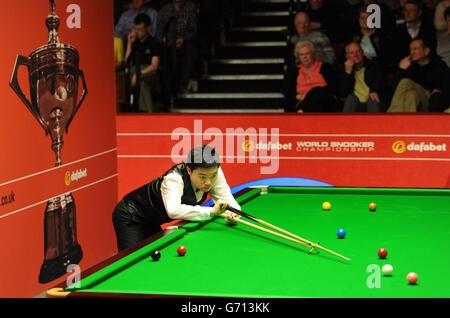 Ding Junhui al tavolo nella sua prima partita contro Michael Wasley durante il Dafabet World Snooker Championships al Crucible di Sheffield. Foto Stock