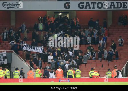 Una visione generale di stewards, polizia e lasciare Newcastle tifosi alla fine del gioco Foto Stock