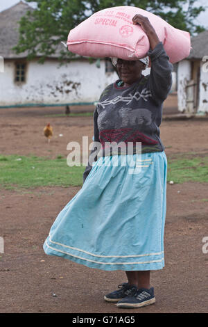 Zulu donna che trasportano il sacco sulla testa, Hidden Valley, KwaZulu-Natal, Sud Africa Foto Stock