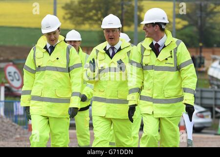 Il cancelliere George Osborne (sinistra) e il primo ministro David Cameron (centro) sono mostrati lo schema di miglioramento della M1 Junction 19 da Mark Sutton, responsabile della costruzione di Skanska (destra). Foto Stock