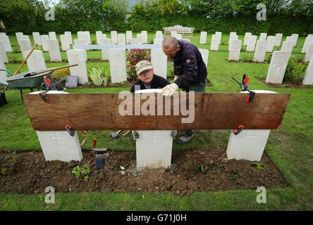 Il giardiniere Caretaker First Class Myles Hunt (a sinistra) al cimitero di guerra di Bayeux in Normandia, con il suo assistente Jean-Claude Menoux, allineare l'ultimo di poco più di 4,000 lapidi che sono stati sostituiti a Bayeux, Mentre la Commissione delle tombe di guerra del Commonwealth (CWGC) sta lavorando per sostituire migliaia di lapidi cadute e danneggiate nei suoi cimiteri in tutta la Francia e oltre, in quanto segna sia il 70° anniversario degli sbarchi in Normandia, sia il centenario della prima guerra mondiale. Foto Stock