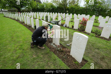 Il giardiniere Caretaker First Class Myles Hunt allinea una delle oltre 4,000 lapidi che sono state sostituite a Bayeux, mentre la Commissione delle tombe di guerra del Commonwealth (CWGC) sta lavorando per sostituire migliaia di lapidi cadute e danneggiate nei suoi cimiteri in tutta la Francia e oltre, Come si celebra sia il 70° anniversario degli sbarchi in Normandia, sia il centenario della prima guerra mondiale. Foto Stock