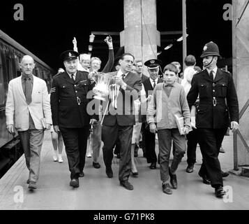 Harry Catterick, manager di Everton, ha una scorta di polizia e tifosi che porta con orgoglio la fa Cup in treno quando lascia la stazione di Euston, per tornare a casa con la sua squadra trionfando a Liverpool. Foto Stock